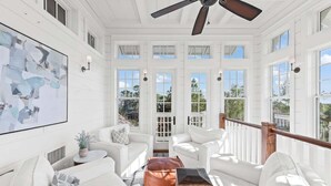 A bright, white room with a ceiling fan, large windows, and a view of the outdoors. - Watersound Beach! With Carriage House, Private Pool, LSV/Golf Cart, & 4 Bikes! (Watersound)