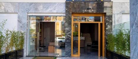 A modern hotel entrance with a glass door and a wooden frame.