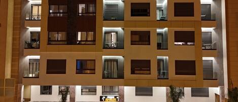 A multi-story hotel with illuminated windows and a ground-level entrance.