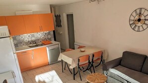A compact living space with a kitchenette, dining area, and seating area.