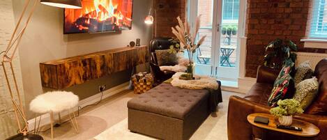 A cozy living room with a fireplace, a comfortable sofa, a coffee table, and a floor lamp.