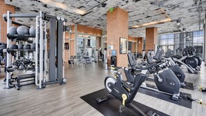 A gym with various exercise equipment, including weight machines, free weights, and cardio machines. - 2BR Ocean Penthouse: Private Terrace & Hot Tub (Hollywood)