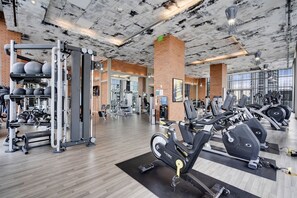 A gym with various exercise equipment, including weight machines, free weights, and cardio machines. - 2BR Ocean Penthouse: Private Terrace & Hot Tub (Hollywood)