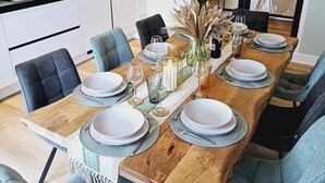 A modern dining area with a wooden table set for six, surrounded by matching chairs.