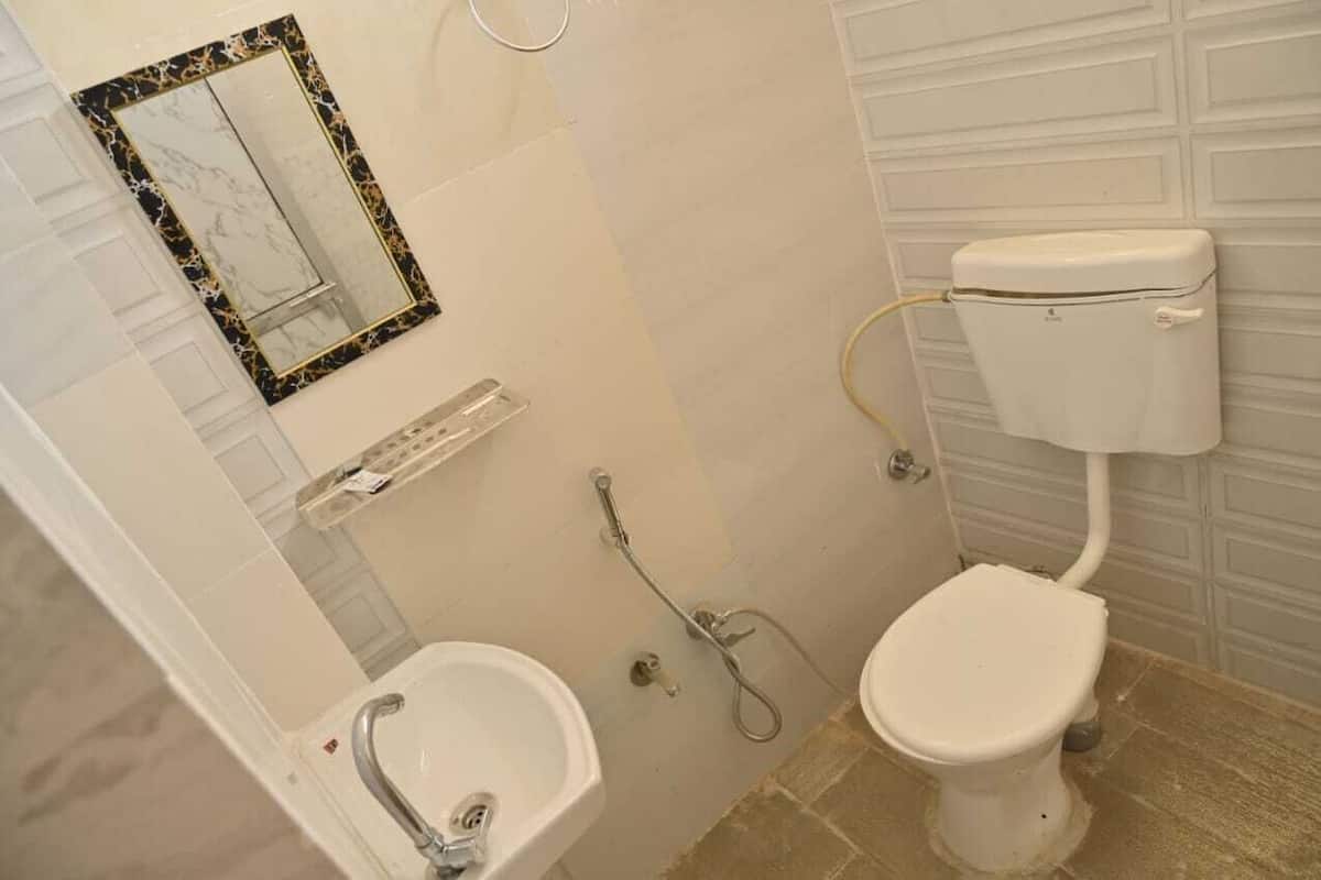 Een badkamer met toilet, bidet en spiegel met een marmeren omlijsting.