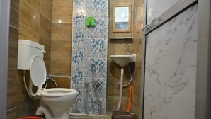 Une salle de bain avec des toilettes, un lavabo et une douche.