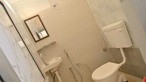 Une salle de bain avec des toilettes, un lavabo et une douche.