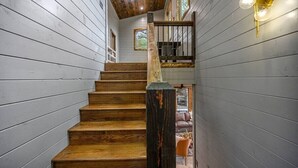 A wooden staircase with a rustic design, leading to a lower level. - All the Vibes + 2 Story + Shuffle Board + Split Floor Plan + Ride to ATV Trails (Broken Bow)