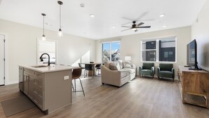 A spacious living area with a kitchen island, a dining table, and a sofa. - Heart and Sol: Desert Color Lagoon + Beaches (St. George)