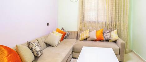 A living room with two sofas, a white coffee table, and patterned cushions.