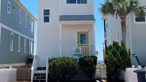 A two-story building with a central entrance, a small porch, and a palm tree. - "The Sandy Turtle" Beachfront bungalow, pet friendly Sleeps 8 (Eastpoint)