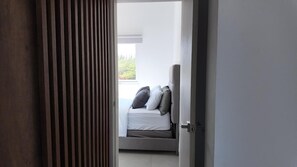 Une chambre à coucher avec un lit, des oreillers et une fenêtre.