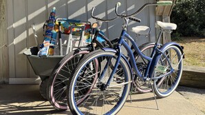 A bicycle parked next to a shed with a sign reading "Nag's Head, North Carolina".