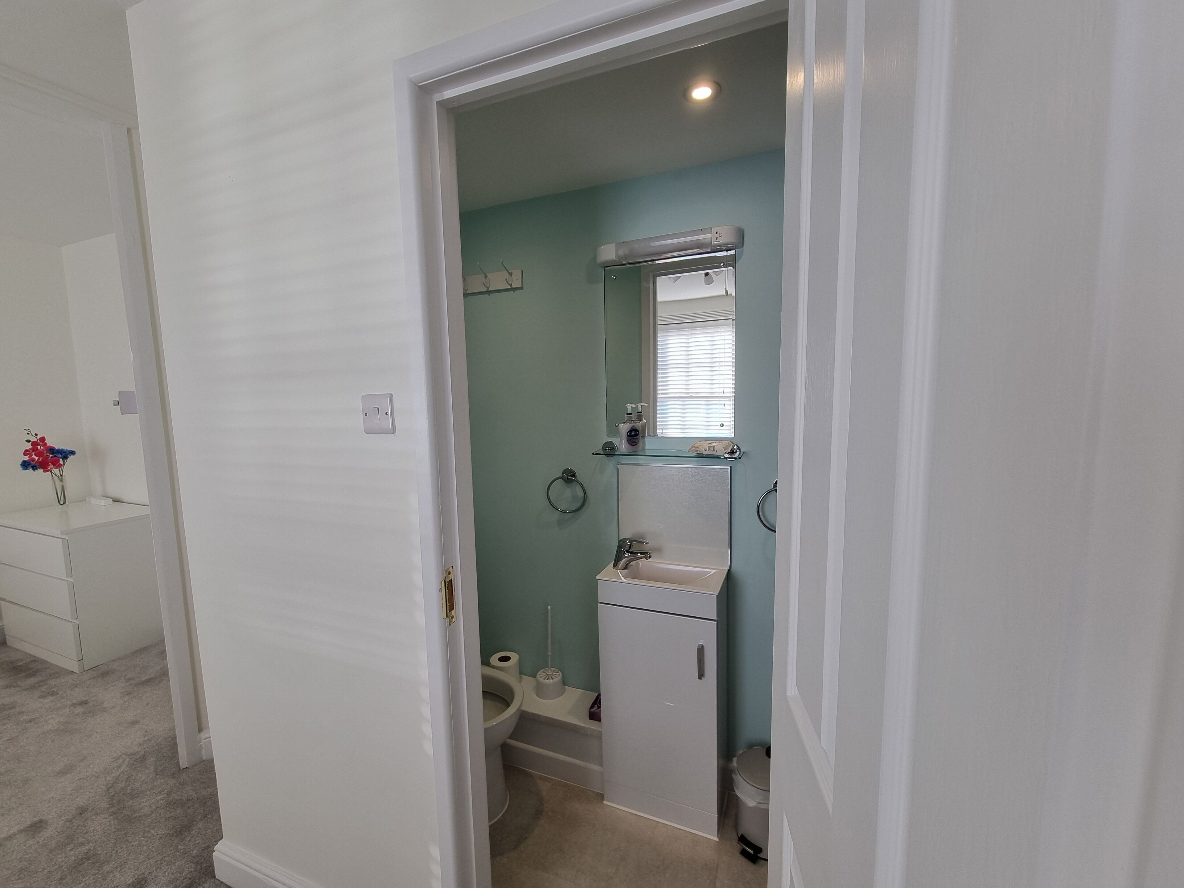 Une petite salle de bain avec des toilettes, un lavabo et un miroir.