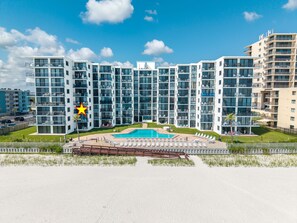 Een meerlaags hotel met een zwembad en terras.