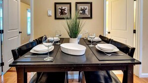 A dining table set with white plates, wine glasses, and a centerpiece. - Bluebird Day - Twin Mills Bungalow in Bend, OR, featuring 2 cozy bedrooms. (Bend)