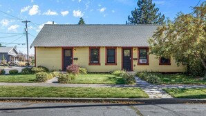 A single-story yellow building with a dark roof, a front porch, and a small front yard. - Bluebird Day - Sierra Nook, one-bedroom retreat in Bend, ideal for couples and pet-friendly. (Bend)