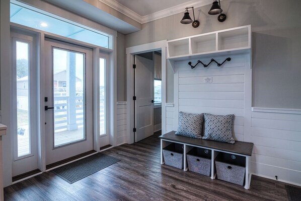 A spacious entryway with a bench, built-in storage, and a door leading to a balcony.