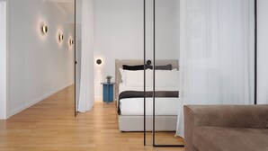 A modern bedroom with a bed, bedside table, and a small plant. - Acropolis Classy Apartments (Athens)