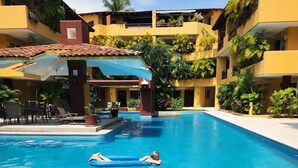 A swimming pool with a person lying on an inflatable float. - Luxury on stunning La Ropa beach in tropical Zihuatanejo Mexico (Zihuatanejo México)