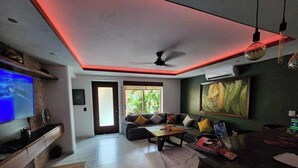 A modern living room with a flat-screen TV, a sofa, a coffee table, and a painting on the wall. - Luxury on stunning La Ropa beach in tropical Zihuatanejo Mexico (Zihuatanejo México)