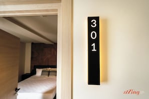A hotel room with a bed, a nightstand, and a wall-mounted sign displaying the number 301. - Florian Boutique Guest house (Cospicua)