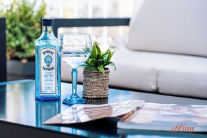 A bottle of Bombay Sapphire Gin, a glass, and a small plant on a table. - Florian Boutique Guest house (Cospicua)