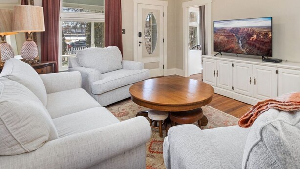 A living room with a sofa, a coffee table, a television, and a cabinet.