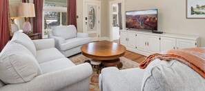 A living room with a sofa, a coffee table, a television, and a cabinet. - City Park Charm - Vintage Home w/ Modern Comforts (Fort Collins)