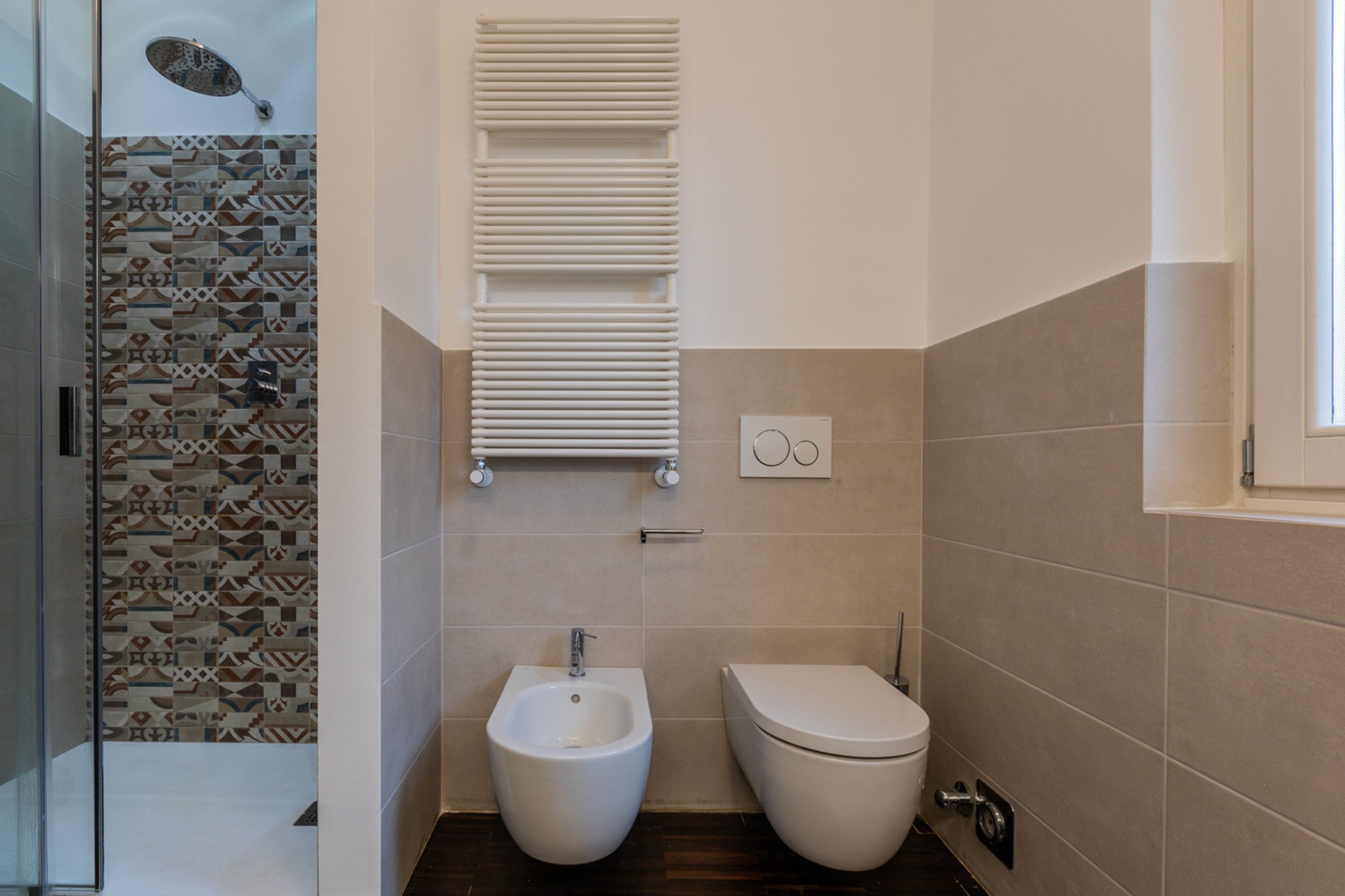 Un bany modern amb bidet, vàter i plat de dutxa.