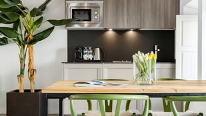 A modern kitchen with a built-in microwave, a coffee maker, and a kettle on the counter.