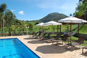 Alberca al aire libre, sombrillas en la alberca y camastros 