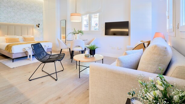 Una sala de estar moderna con un sofá, una silla, una mesa de centro y un televisor.