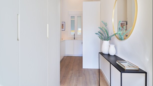 A hallway with a black console table, white vases, and a gold-framed mirror. - iloftmalaga Playamar I (Torremolinos)