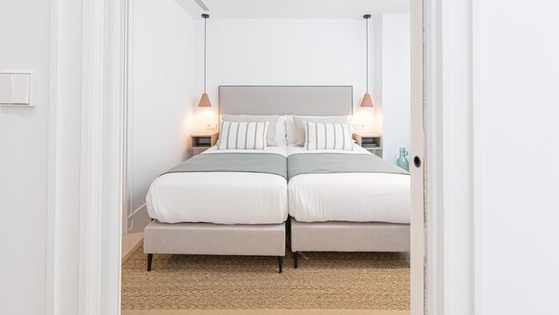 Een moderne slaapkamer met een tweepersoonsbed, nachtkastjes en een plafondventilator.
