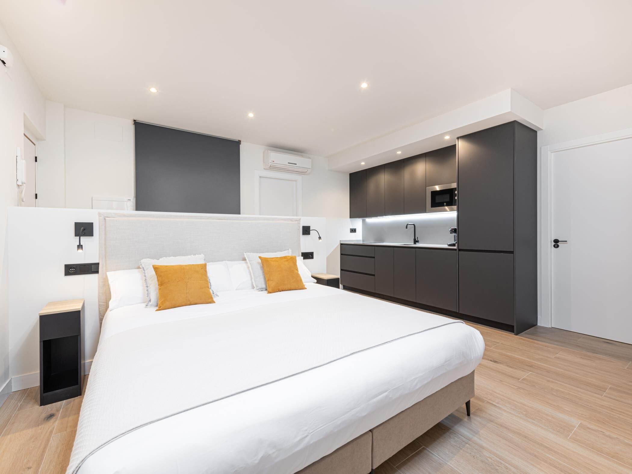 Un dormitorio moderno con una cama grande, mesitas de noche y un armario empotrado.