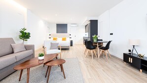 A modern living room with a sofa, coffee table, and dining area. - Barroso II - iloftmalaga (Málaga)