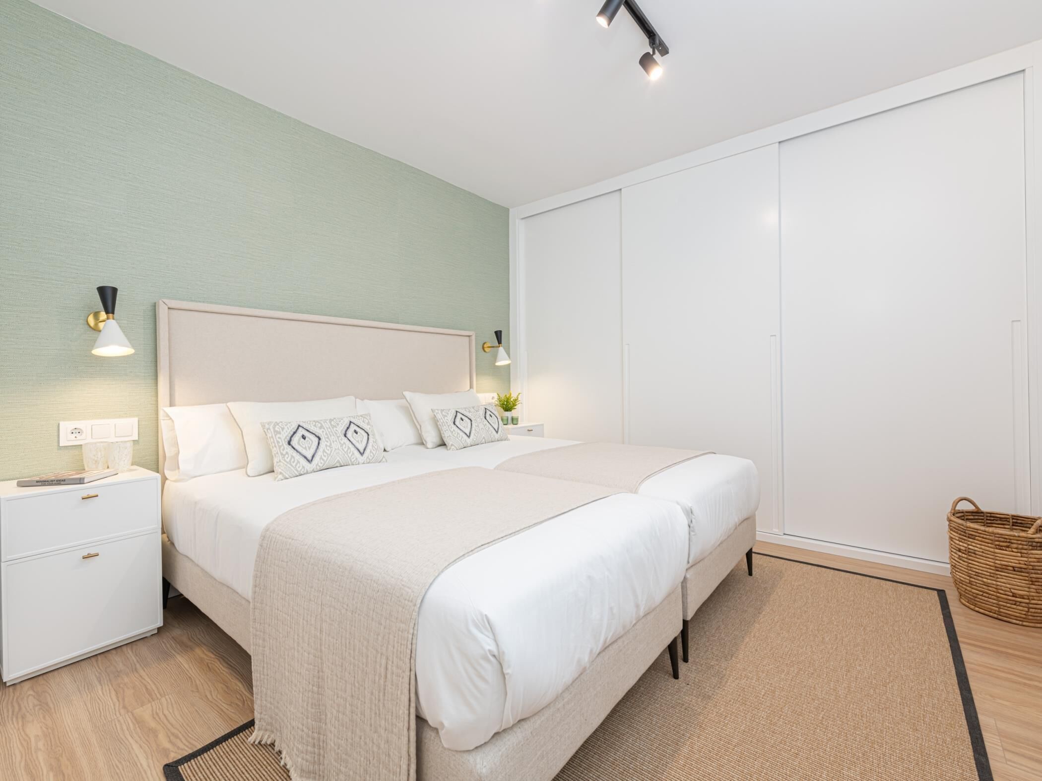 Ein Schlafzimmer mit Bett, Nachttischen, einer Lampe und einem Kleiderschrank.