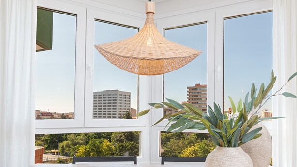 A room with large windows, a woven pendant light, and two large potted plants. - Avenida Andalucía - iloftmalaga (Málaga)