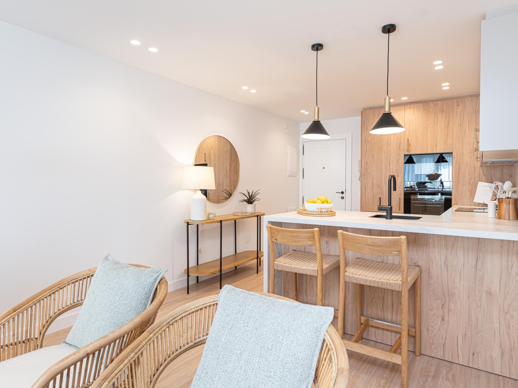 Een moderne keuken met houten kastjes, een centraal eiland en hanglampen.