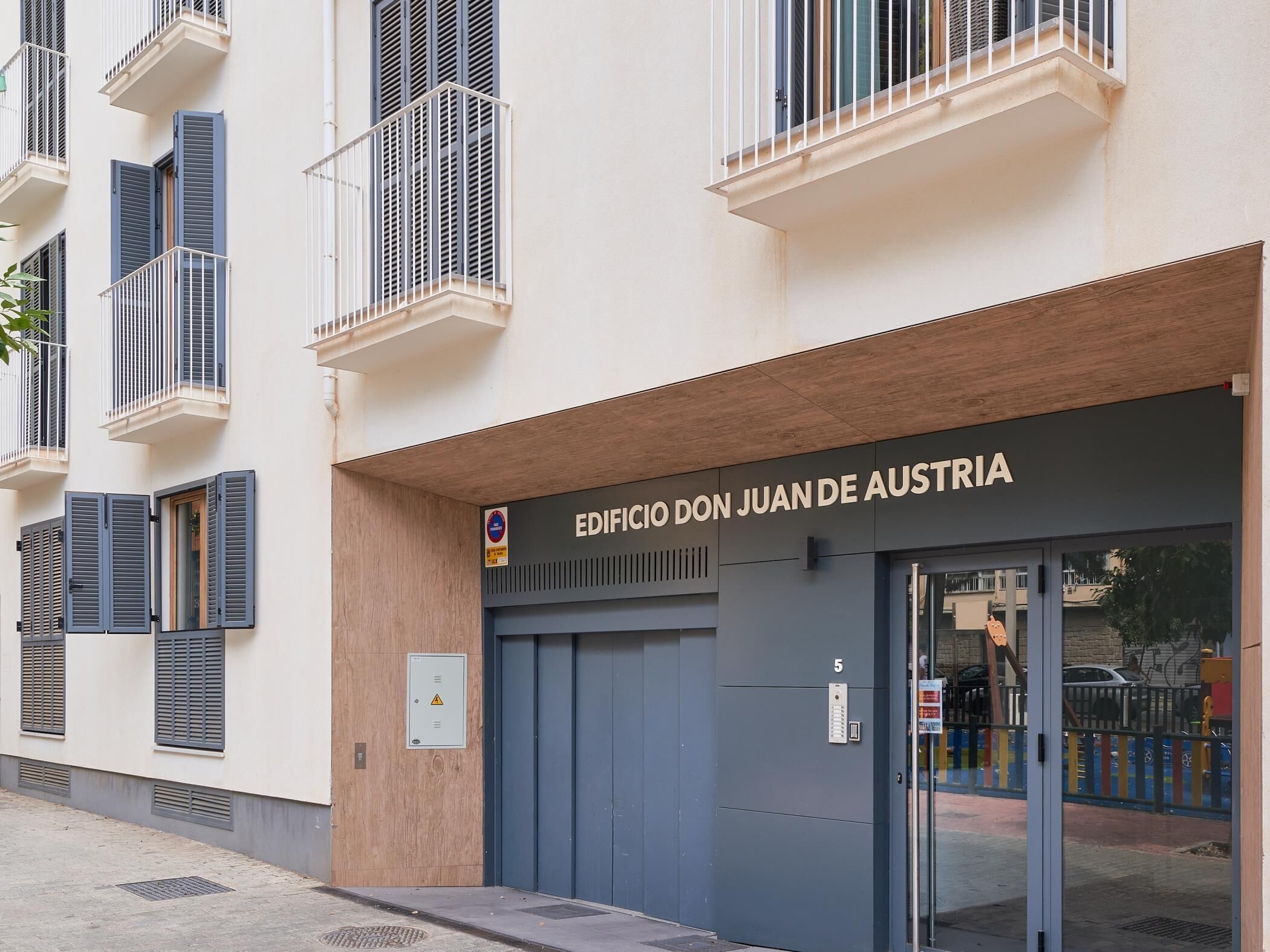 Exterior de un edificio con un cartel que dice 'EDIFICIO DON JUAN DE AUSTRIA'.