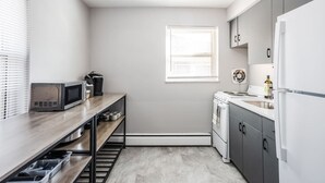 A compact kitchen with a microwave, coffee maker, and a small window.