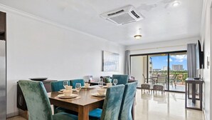 Comedor con mesa de madera dispuesta para seis personas, rodeado de sillas tapizadas en color aguamarina.