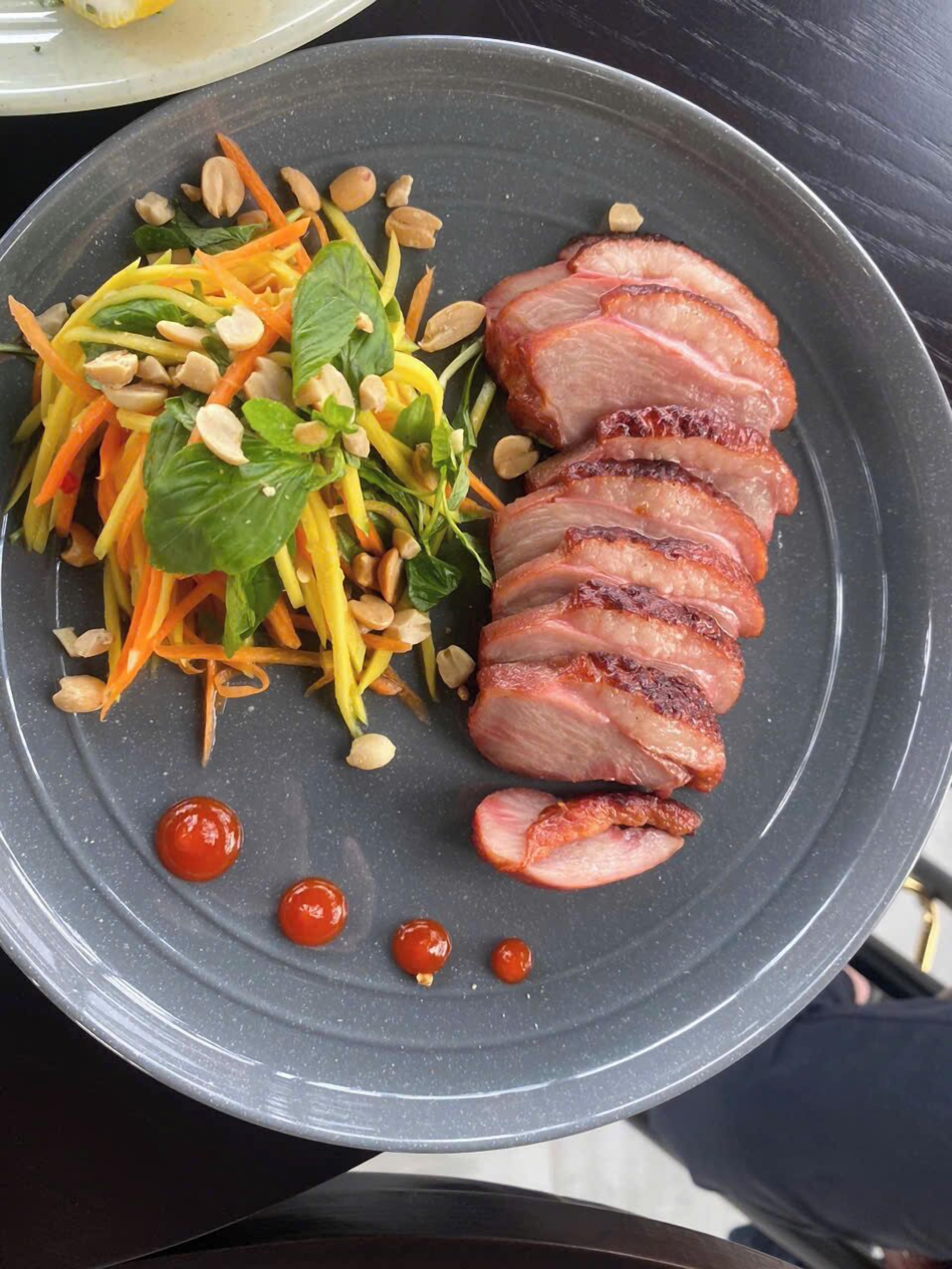 A plate with sliced meat and a vegetable salad.