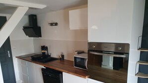 A compact kitchen with a dishwasher, microwave, and built-in oven. - Cosy apartment for curists or tourists (sleeps 2 to 6) (Saujon)