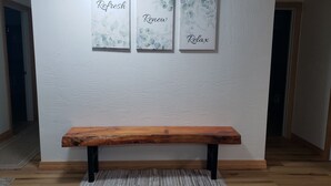 A wooden bench with a rug in front of a white textured wall with three framed artworks displaying the words "Refresh," "Renew," and "Relax." - LAUREL HIGHLANDS MOUNTAIN RETREAT - Only 7 miles to Ohiopyle! (Confluence)