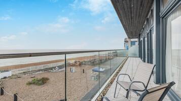 Enjoy a serene beach view from this balcony with a clear view of the sandy shore.