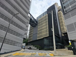 A modern building with a prominent "NORTH POINT CITY" sign, a covered pedestrian walkway, and a street with a yellow crosswalk.