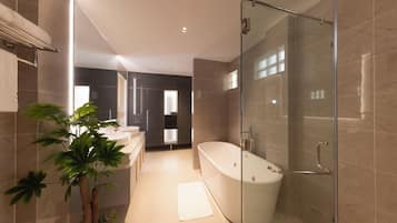 A modern bathroom with a freestanding bathtub, a glass-enclosed shower, and a large potted plant.