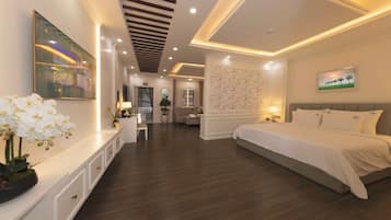 Una habitación de hotel moderna con una cama grande, un área de descanso con una mesa y sillas, y una pared decorativa con un cuadro enmarcado.